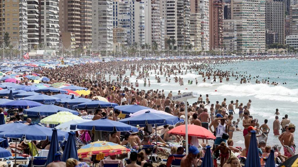 Una playa llena de bañistas.