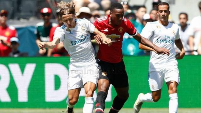 Luka Modric pelea un balón con Martial