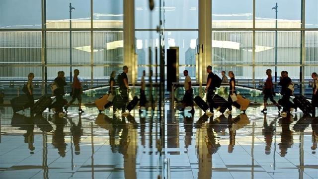 Imagen de pasajeros en tránsito en un aeropuerto.