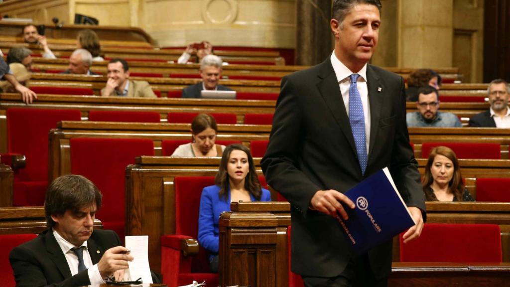 El presidente del PP catalán, de pie, y el presidente de la Generalitat, Carles Puigdemont. (d).