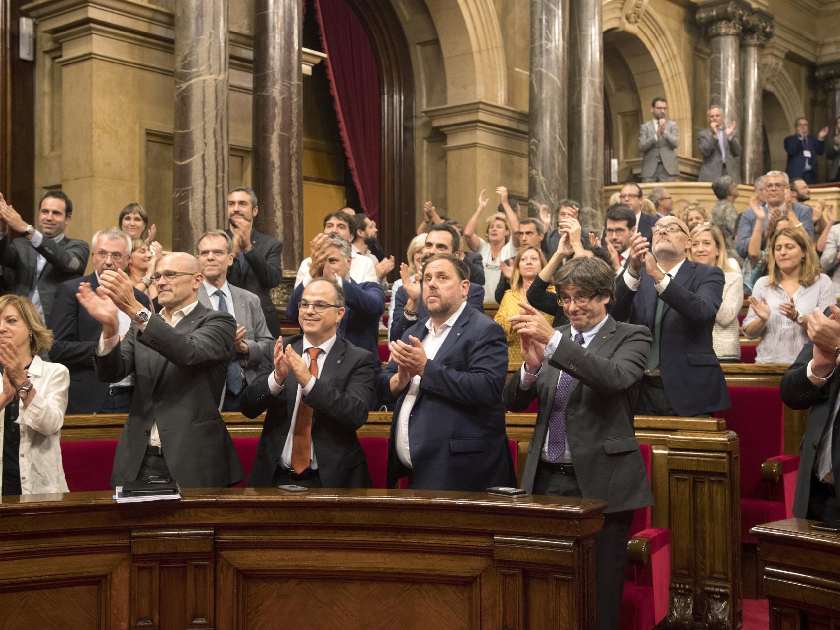 Puigdemont y Junqueras aplauden tras la aprobación de la ley.