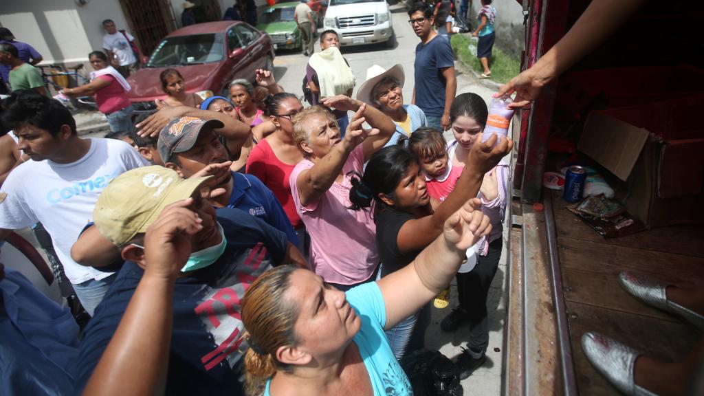 Varias personas esperan a recibir comida y productos de higiene.