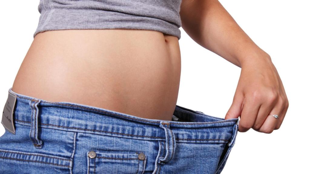Una joven comprueba el efecto que ha tenido en su cuerpo su última dieta.