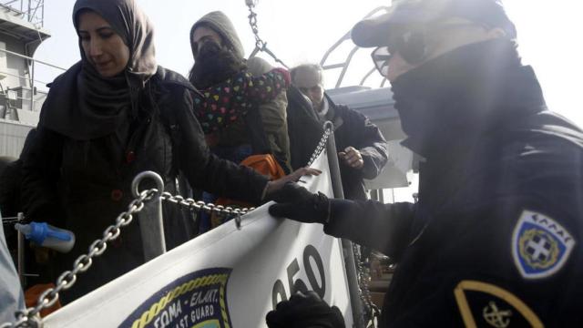 Guardacostas griego con un grupo de refugiados.