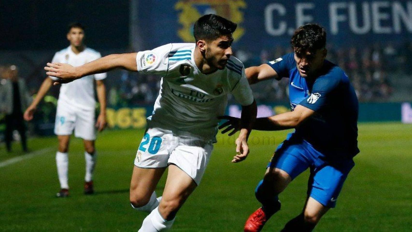 Marco Asensio agarrado por un jugador del Fuenlabrada