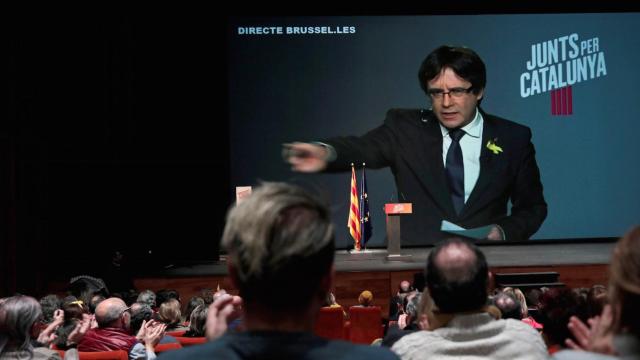 Carles Puigdemont inverviene vía plasma en un acto electoral de su candidatura.