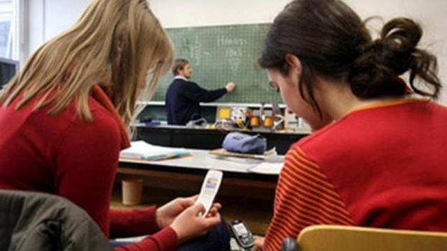 Niñas  usando el móvil en clase en una imagen de archivo.