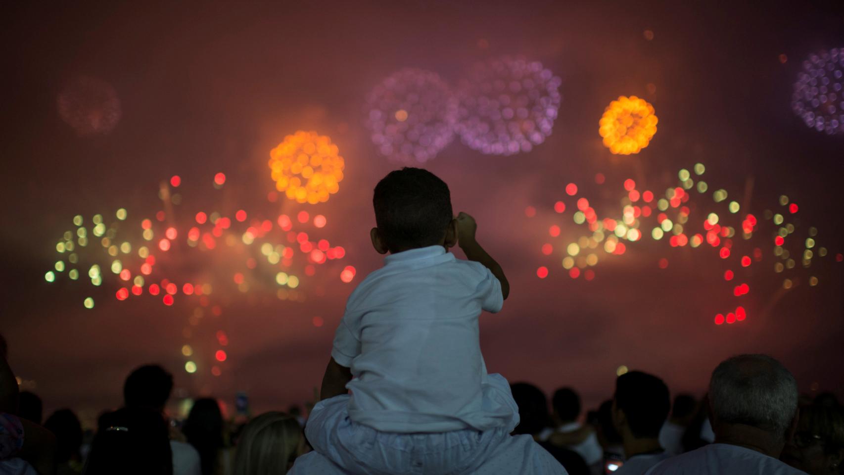 Gente observando los fuegos artificiales sobre Copacabana (Río de Janeiro). /Reuters
