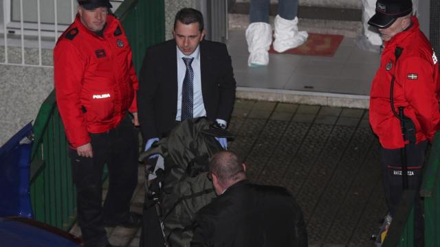 Miembros de los servicios funerarios con el cuerpo de uno de los miembros del matrimonio asesinado.