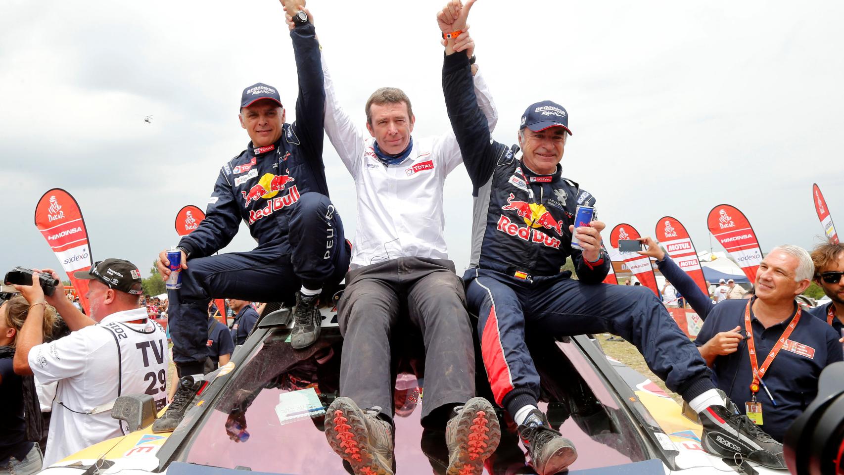 Sainz celebra la victoria con su copiloto Lucas Cruz y el jefe del equipo Reanult.
