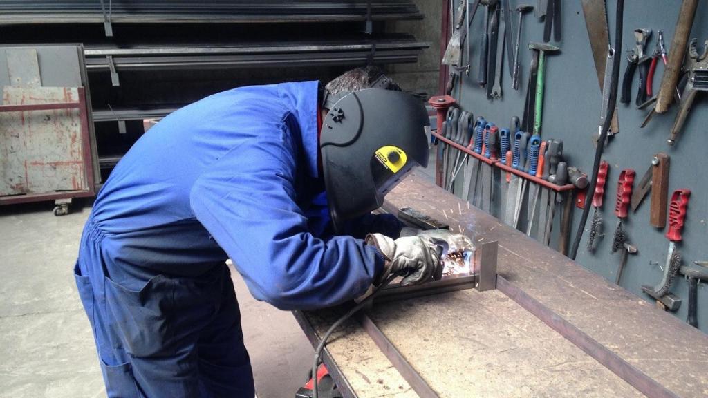 Un hombre trabaja en un taller de soldadura