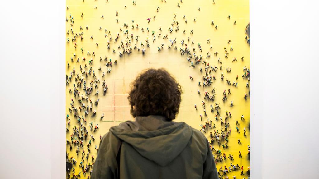 Un visitante en la feria ARCO 2018 observando un cuadro de Juan Genovés.
