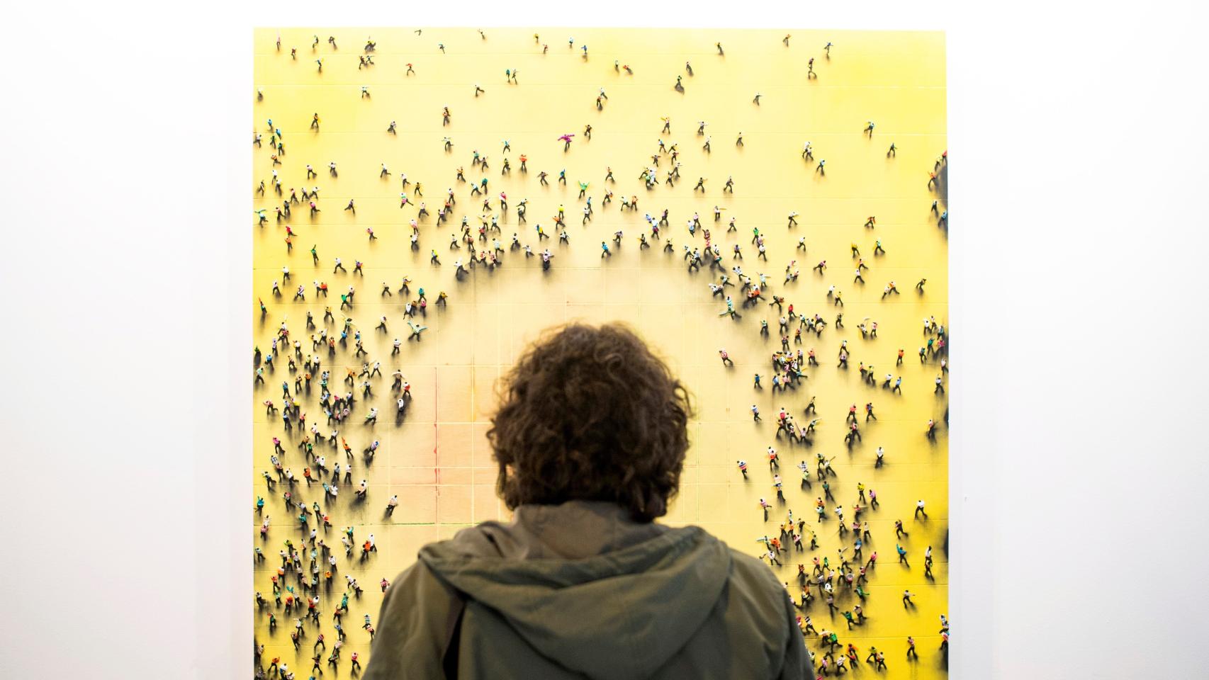 Un visitante en la feria ARCO 2018 observando un cuadro de Juan Genovés.