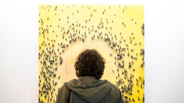 Un visitante en la feria ARCO 2018 observando un cuadro de Juan Genovés.