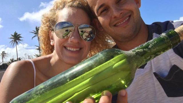 La pareja puertorriqueña sujetando la botella con el mensaje en su interior