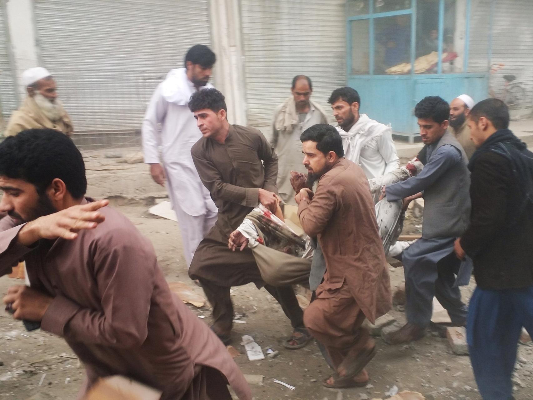Varias personas evacúan a un herido en un atentado en Kabul.