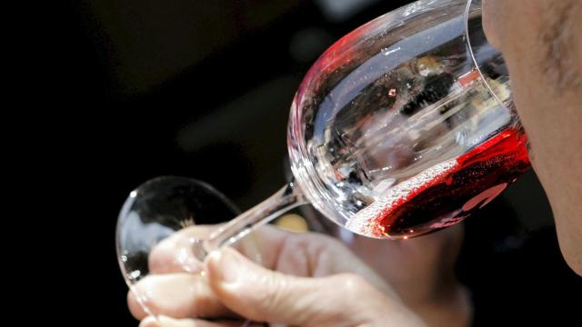 Un joven bebe una copa de vino, en una imagen de achivo.