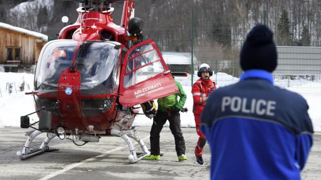 Un policía observa el aterrizaje del helicóptero de Air Zermatt tras la búsqueda en la zona donde se produjo el alud, en Valais.