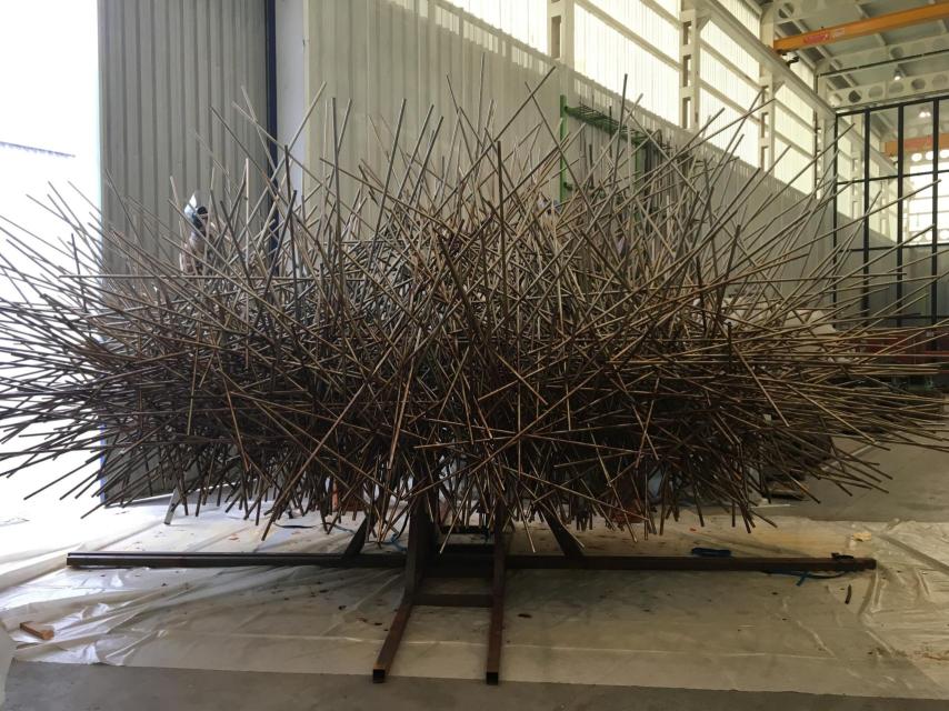 Un par de trabajadores ultiman la corona de una de las cabezas de Manolo Valdés.