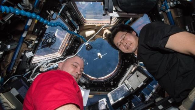Los astronautas Scott Tingle (izquierda) y Norishige Kanai (derecha) en el interior de un cohete de la NASA.