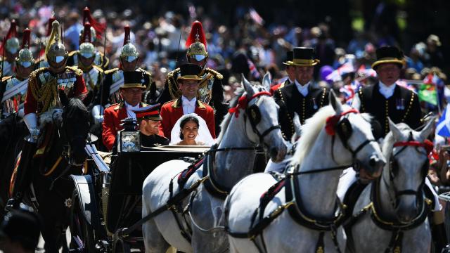 Los recién casados desfilando en el coche de caballos.