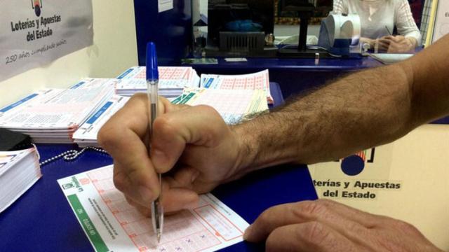 Una persona rellenando un boleto de La Primitiva.