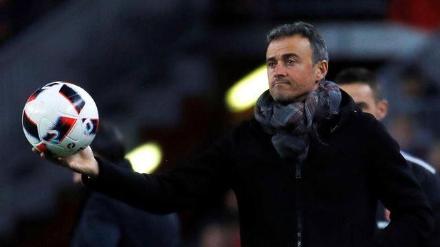 Luis Enrique sostiene el balón para que un jugador saque de banda.