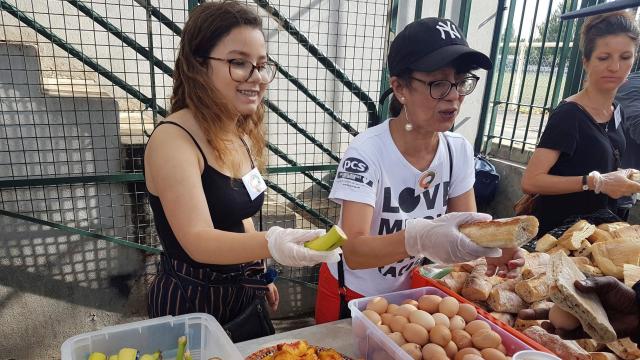 Miembros de la asociación vecinal reparten comida a los migrantes.