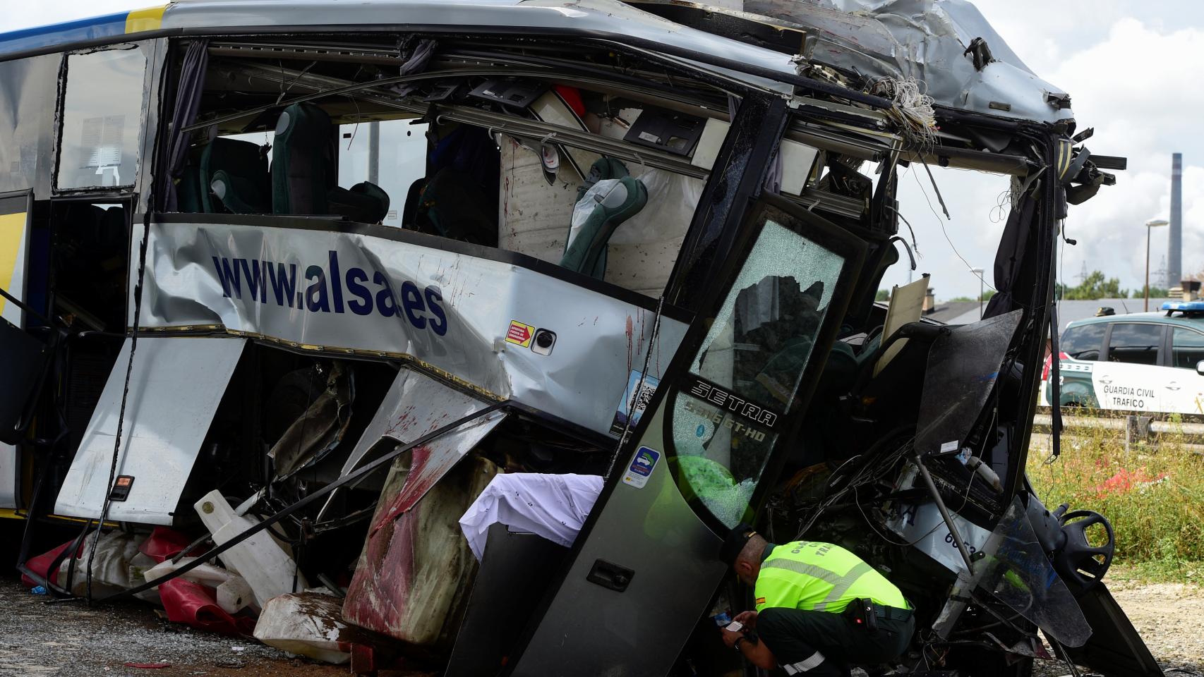 Un policía rebusca entre los escombros del autbús. | REUTERS