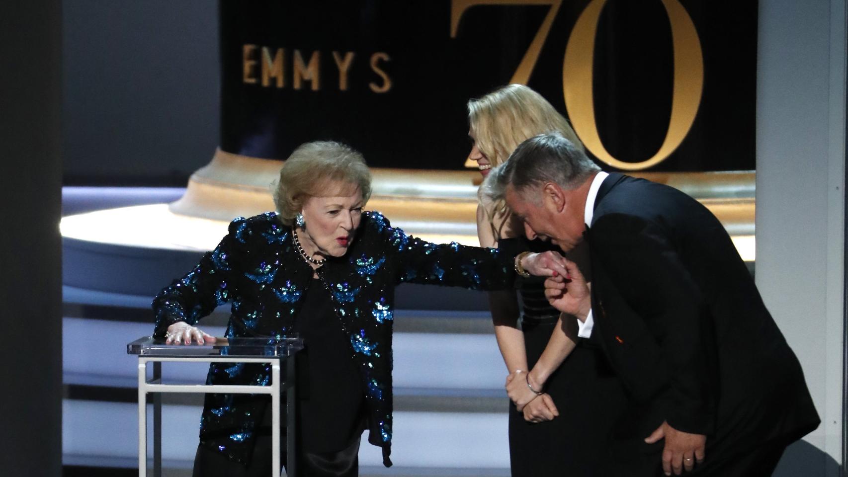 Alec Baldwin besando la mano de Betty White.