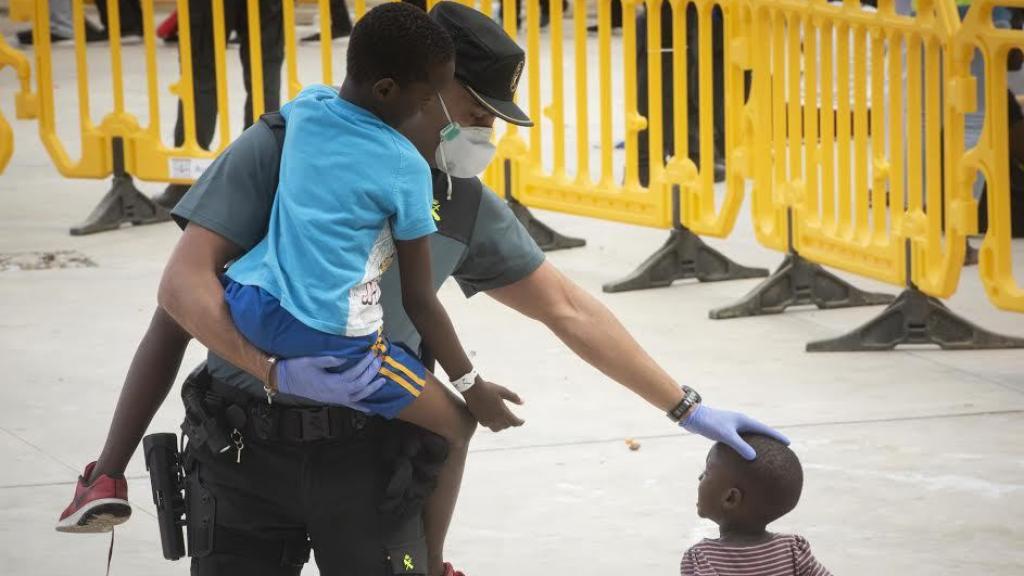Un guardia civil, con dos menores inmigrantes en un polideportivo de Los Barrios (Cádiz) este verano.