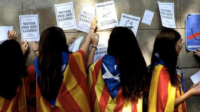 Escolares catalanes pegan carteles a favor de la independencia.