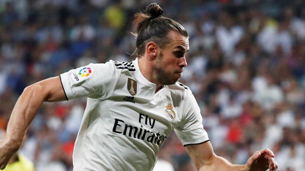 Bale disputa un balón con Godín