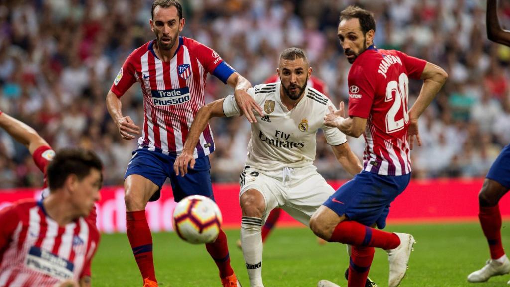 Benzema, ante los jugadores del Atlético de Madrid, Juanfran y el uruguayo Diego Godín