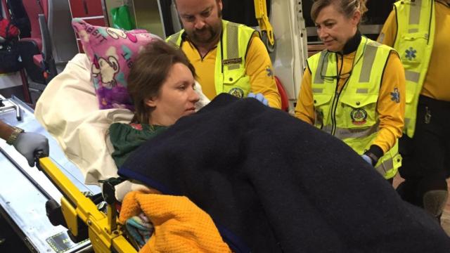 La mujer que ha dado a luz en la calle, al ser trasladada por el Samur.