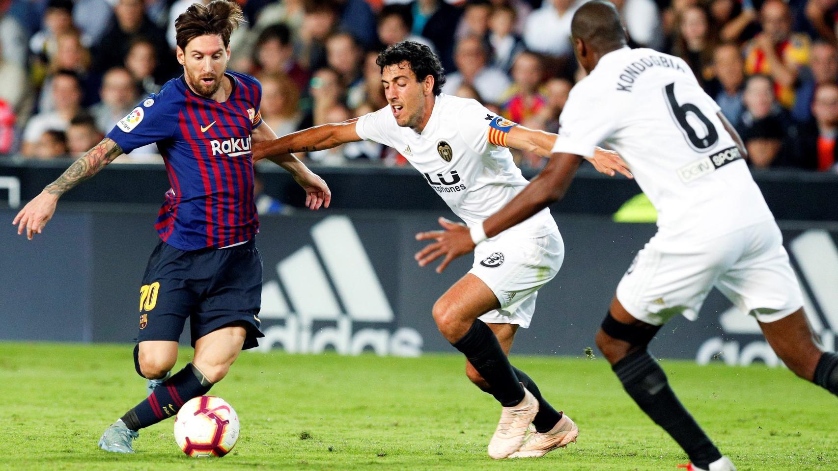 Parejo lucha con Messi por un balón