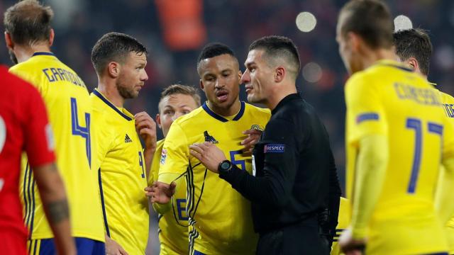 Los futbolistas de Suecia rodean al árbitro