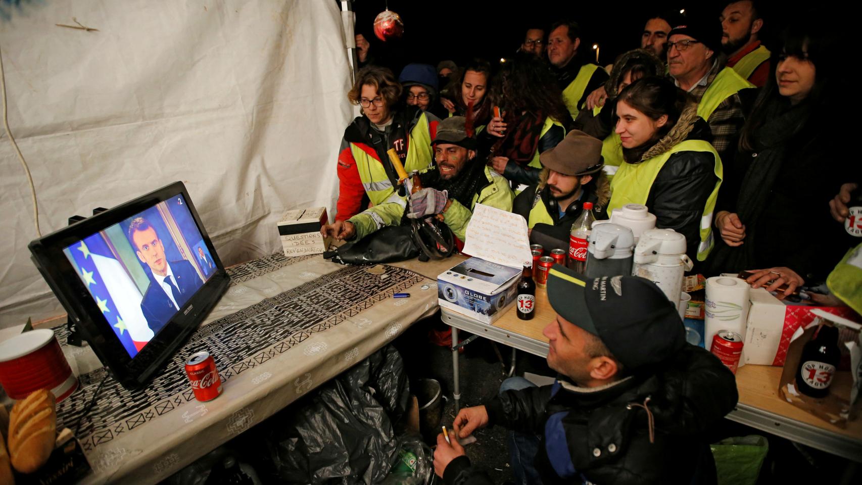 Los 'chalecos amarillos' viendo hace unas semanas la comparecencia de Macron.