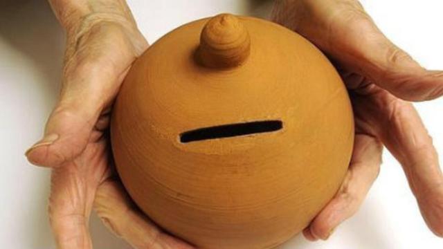 Un ahorradora sostiene una hucha.