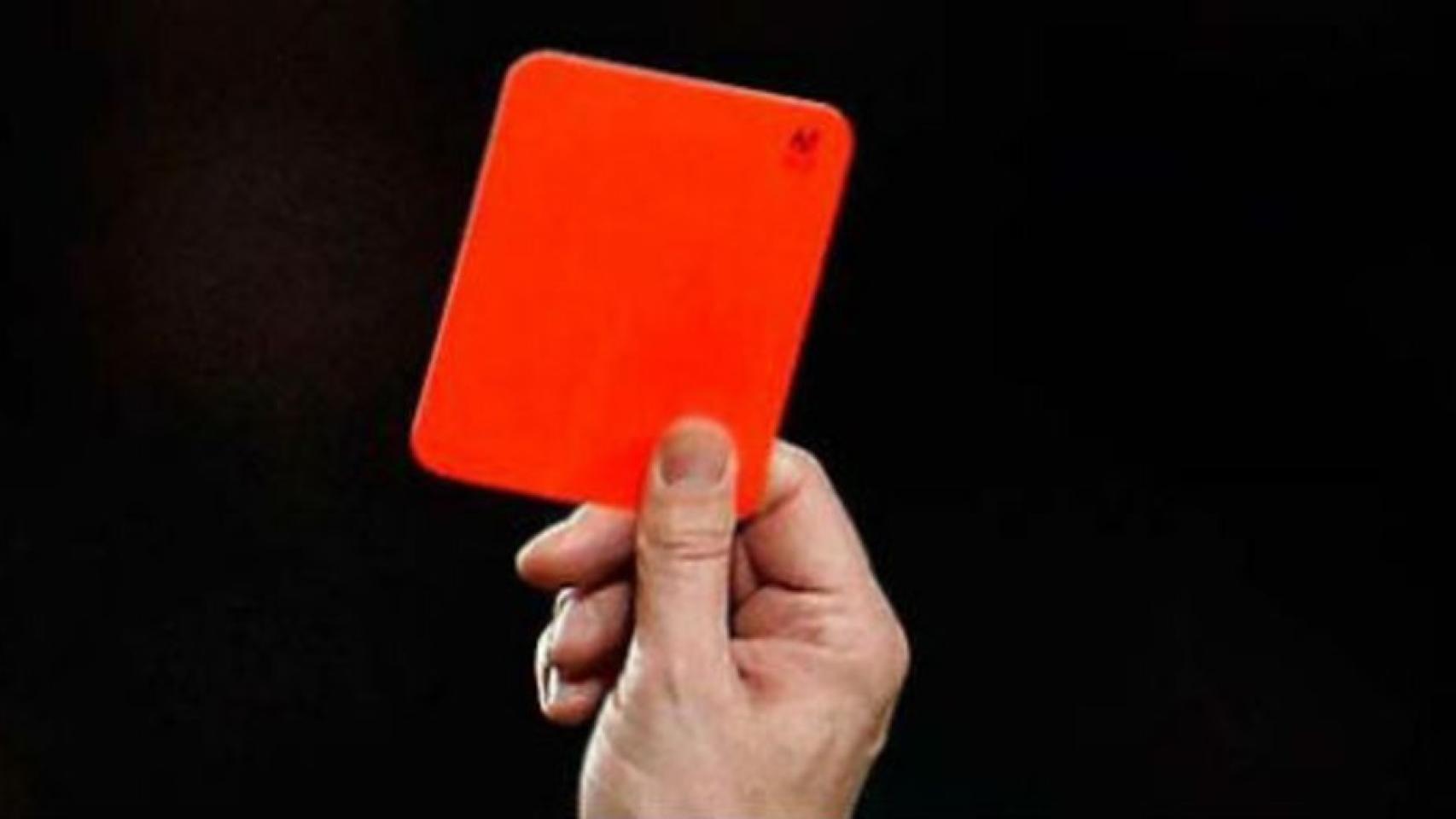 Un árbitro muestra una tarjeta roja.