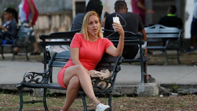 Una mujer navega por Internet en un punto habilitado en La Habana