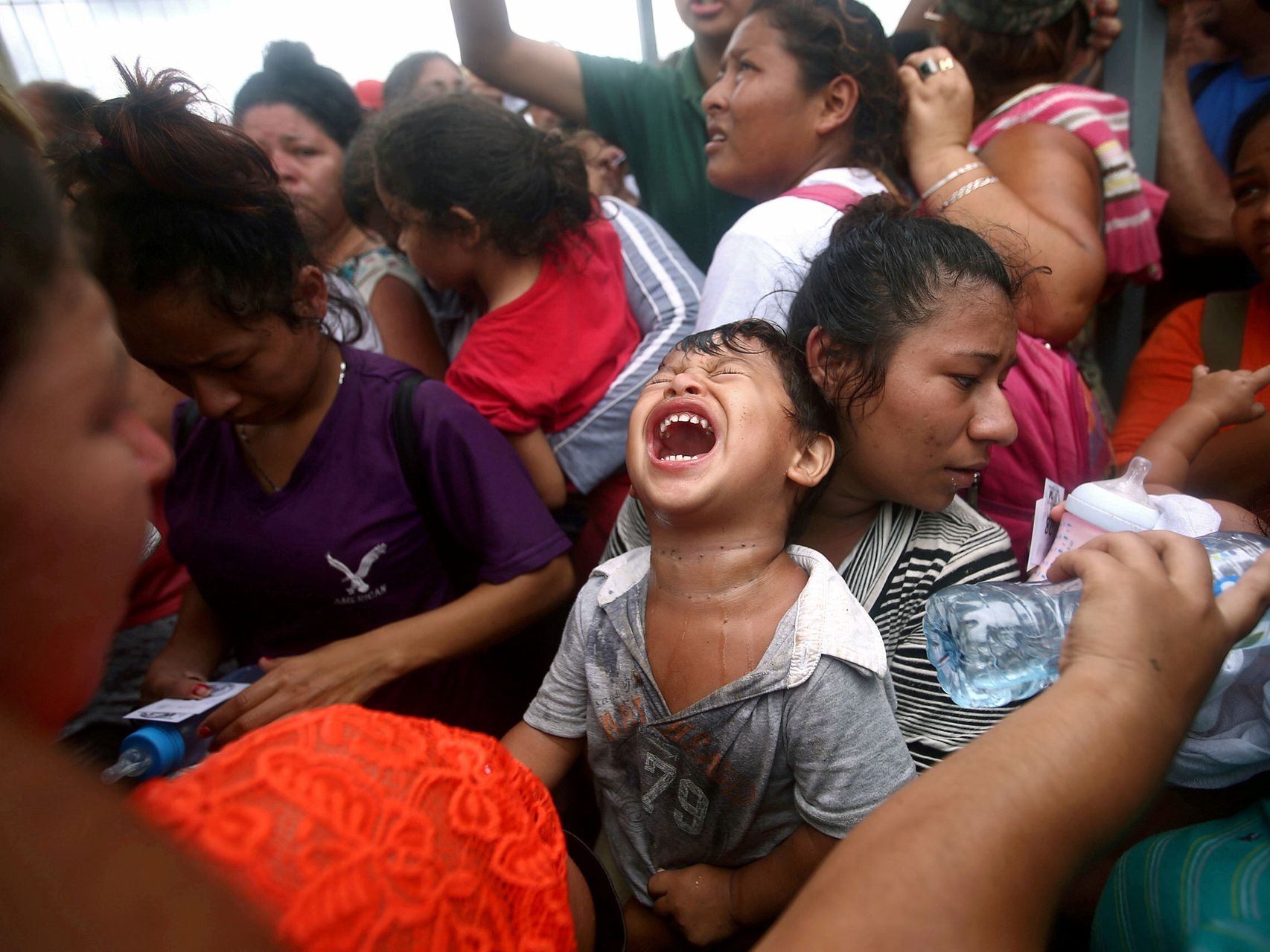 Un niño en brazos de su madre en una caravana de migrantes.