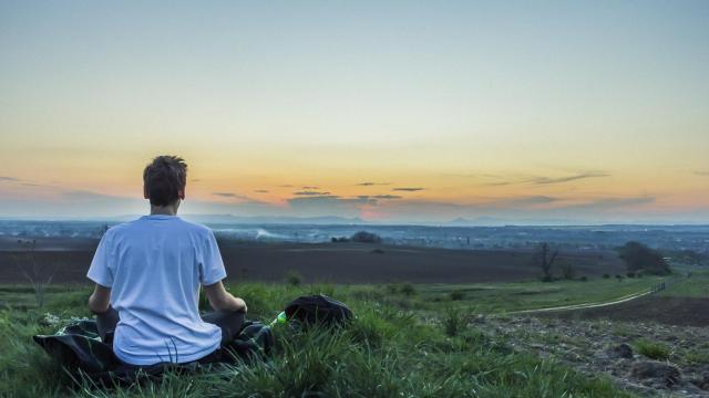 Un joven se relaja mirando al horizonte.