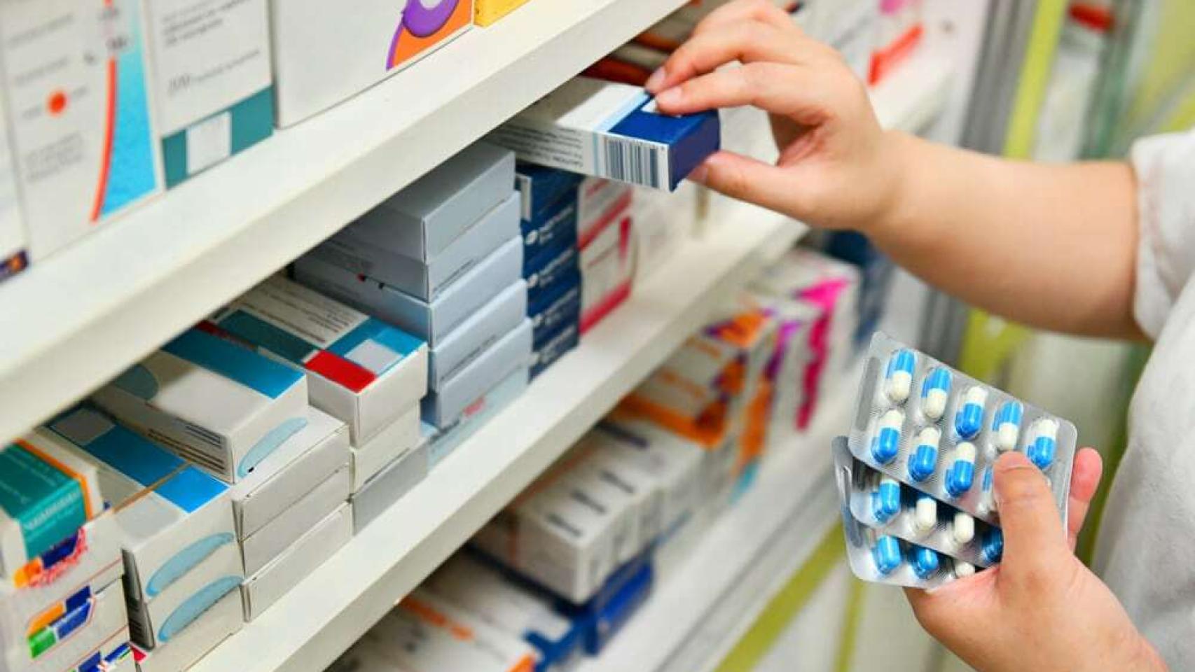 Una farmacéutica coge un medicamento de una estantería (Archivo).