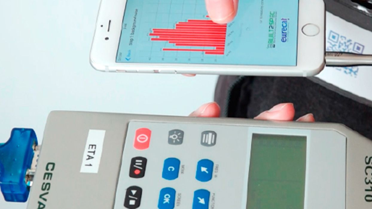 Un sonómetro convencional y un iPhone con la 'app' móvil instalada para una prueba de medida acústica.