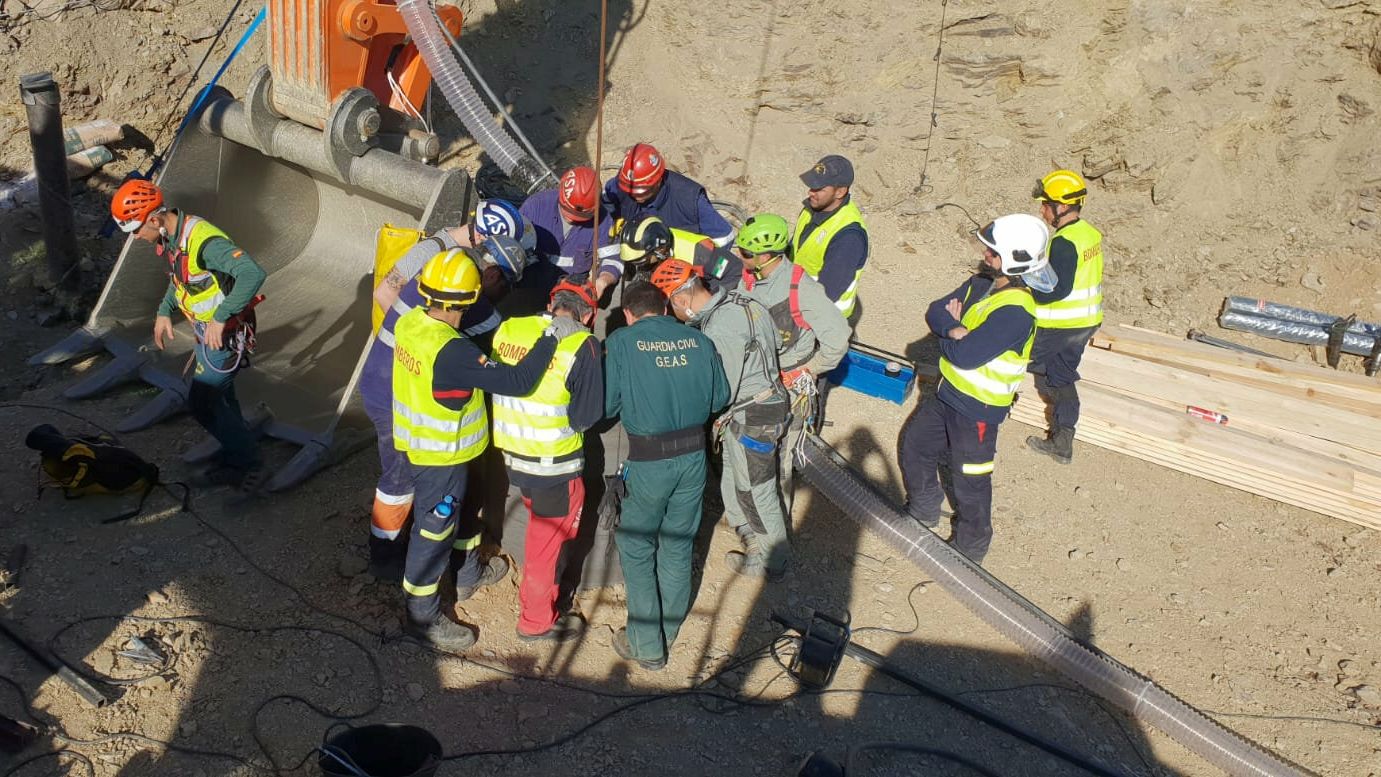 Mineros, especialistas y guardia civil miran el pozo por el que desciende la cápsula.