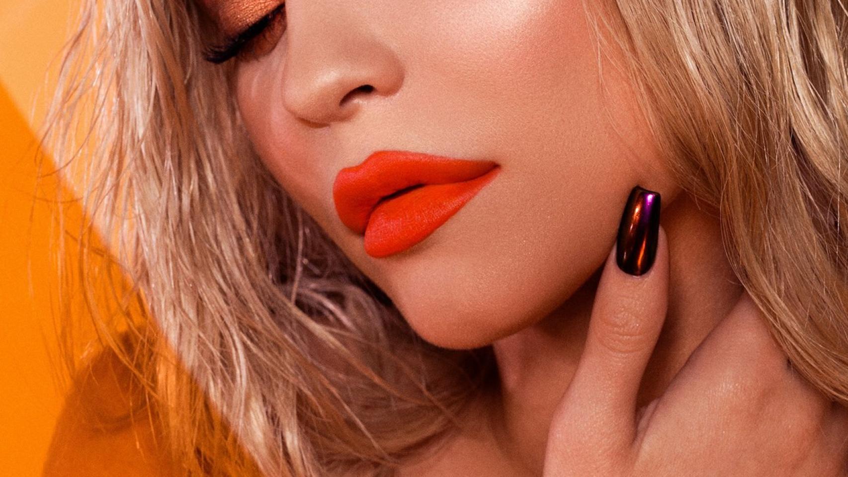 Kylie Jenner anunciando uno de sus pintalabios, en color naranja.