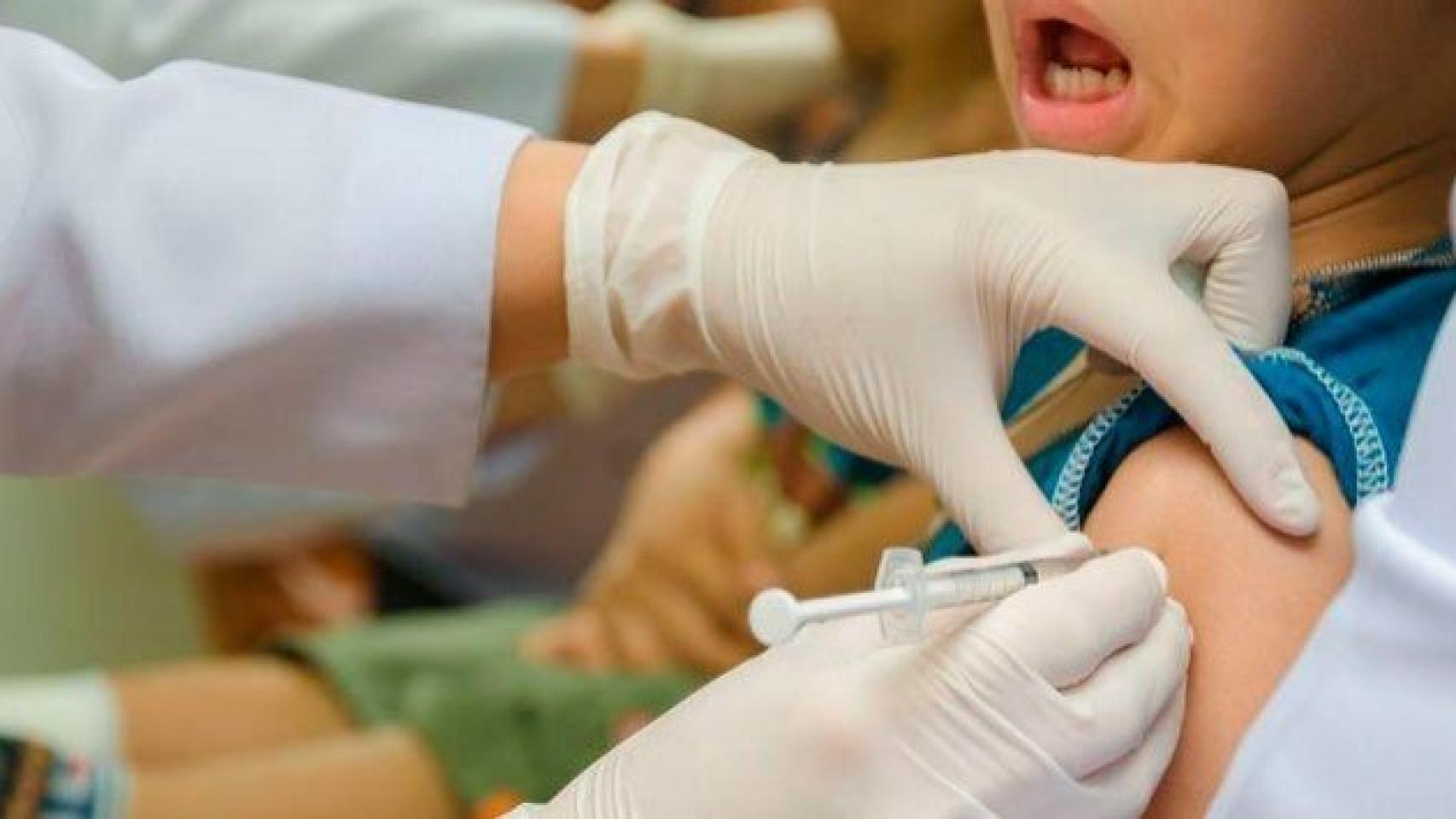 Enfermero vacunando a un niño.