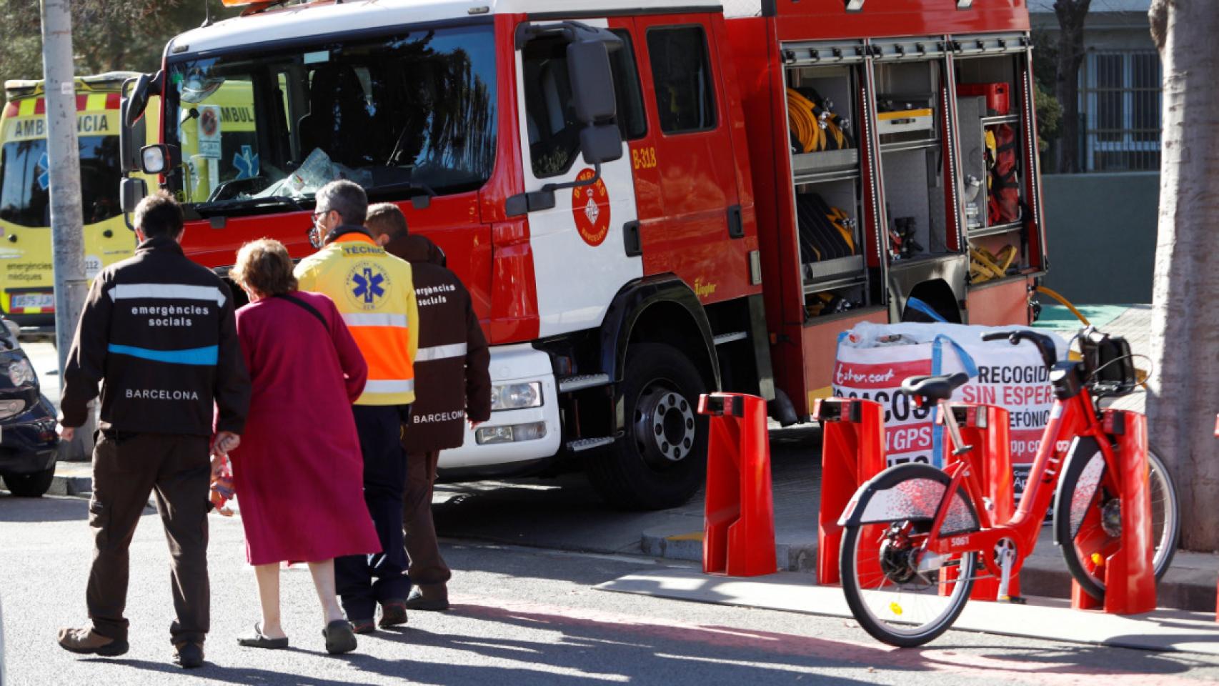 Bomberos de Barcelona atienden a los vecinos afectados por el incendio.