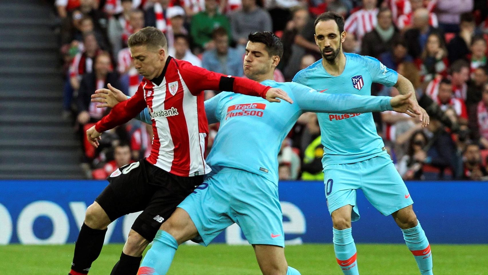 Iker Muniain intenta llevarse el balón ante el acoso de Álvaro Morata